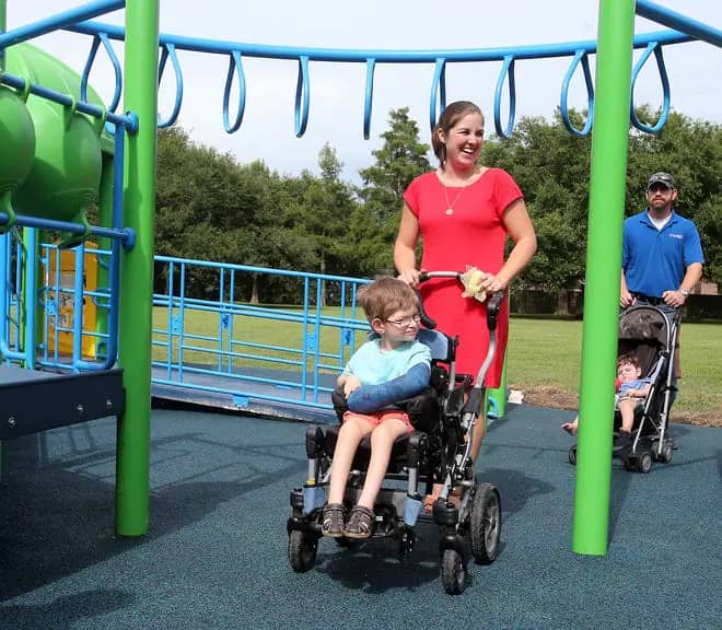 Children and parents using the adaptive playground at Summerfield Park in Houma