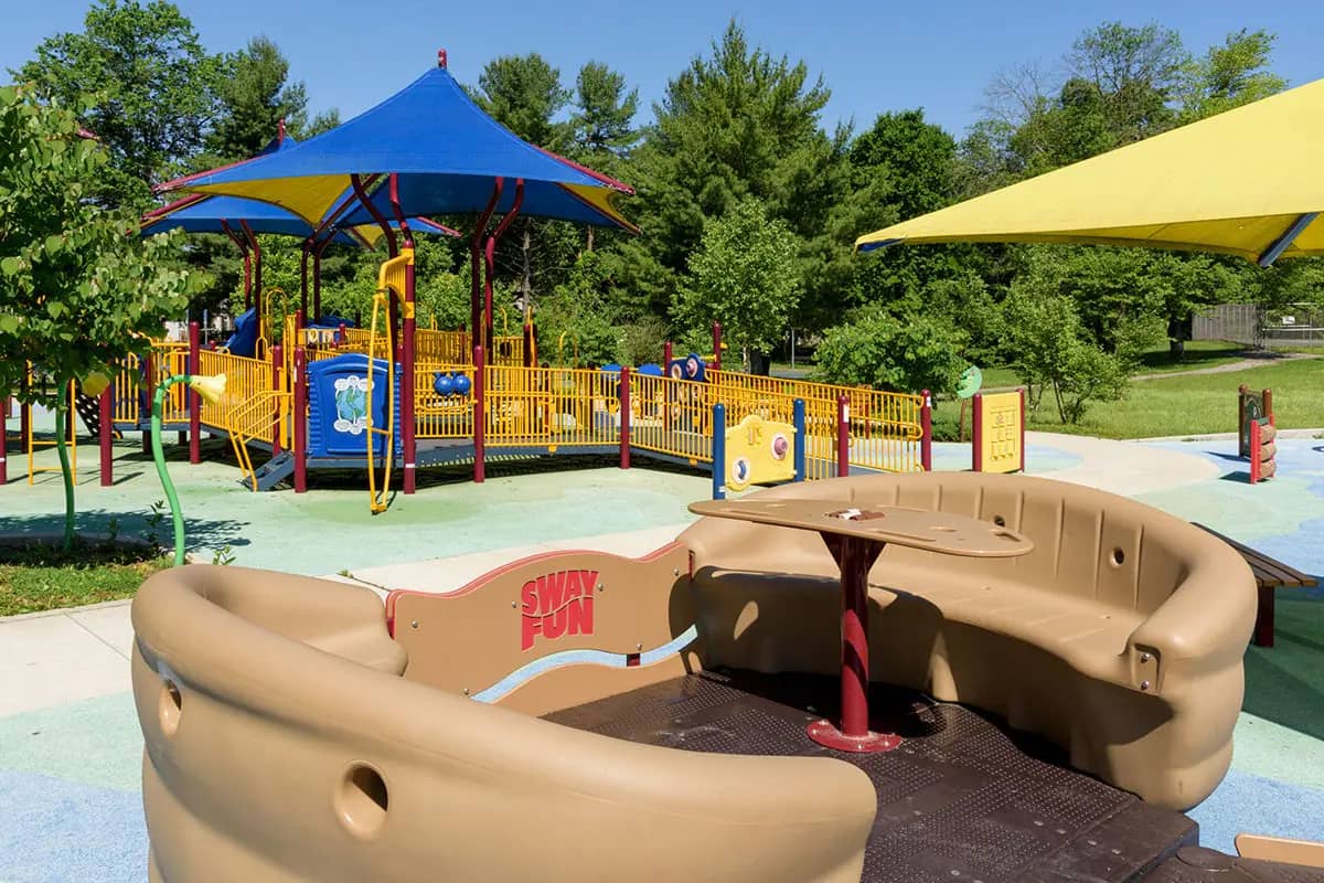 Accessible play structure with ramp and shade umbrellas at Mitchellville South Park in Bowie