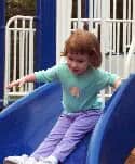 Child going down a slide at Constitution Park in Cumberland