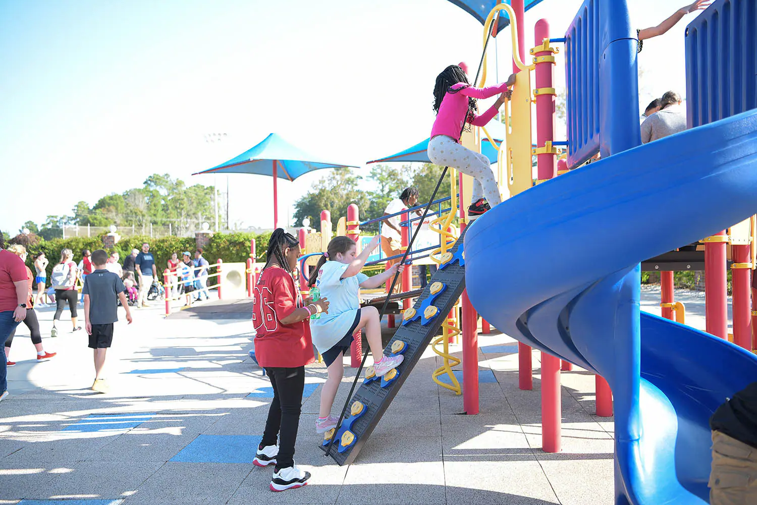 Children climbing on an inclusive playground structure