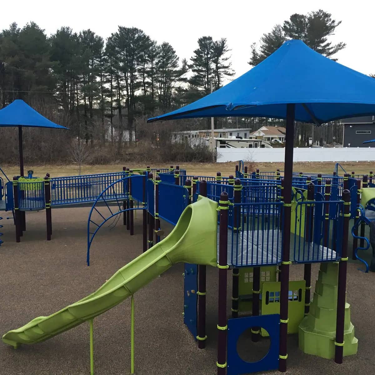 Play structure with shade umbrellas and slides at Jessica's Boundless Playground in Belchertown